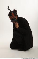 Man Adult Average Black Fighting with gun Sitting poses Coat